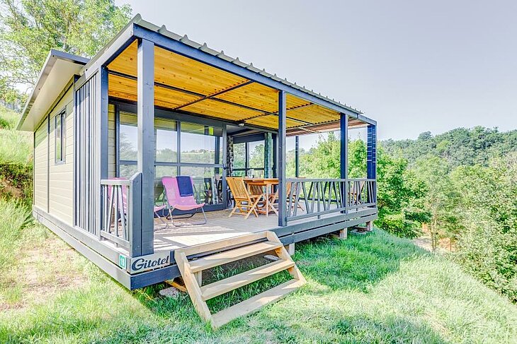 Chalet tout confort avec terrasse ombragée au camping nature L’Oasis à Eclassan, un hébergement idéal pour des vacances en famille au cœur de la nature ardéchoise.