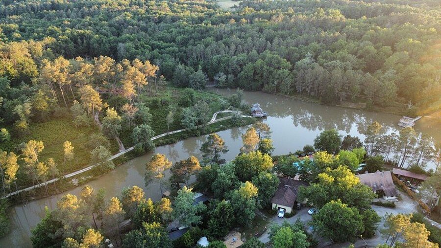 Vue aérienne d’un camping près de Saint-Émilion avec étang et forêt, cadre paisible idéal pour des vacances en camping Saint-Émilion.