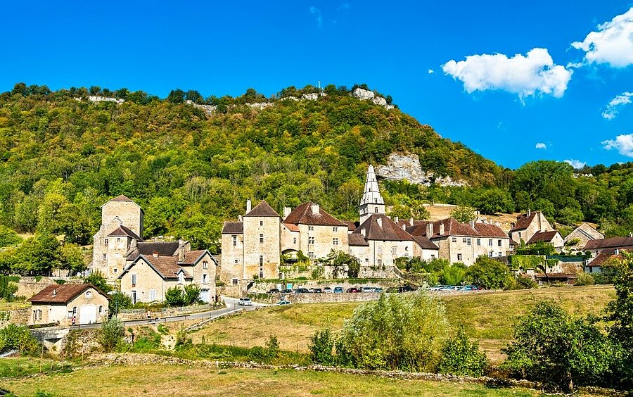 Village de Baume-les-Messieurs au pied des falaises boisées du Jura, à découvrir lors de vacances en camping.