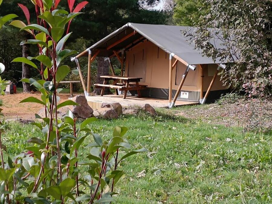 Tente lodge confortable et bien équipée au camping près du Puy de Sancy, offrant un hébergement insolite en pleine nature pour des vacances en harmonie avec l'environnement.