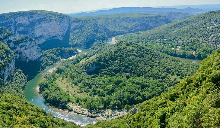Vue panoramique des Gorges de l'Ardèche, un site naturel emblématique d’Auvergne-Rhône-Alpes, idéal pour le canyoning et les randonnées au cœur de paysages spectaculaires.