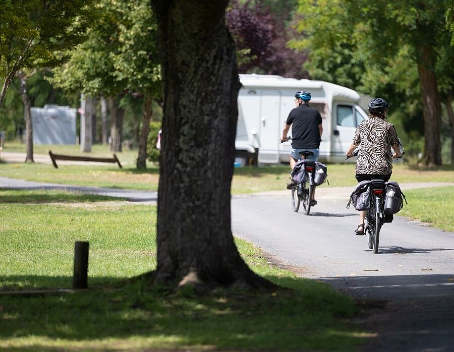 Deux cyclotouristes dans un camping du Val de Loire, prêts à explorer l’itinéraire La Loire à Vélo