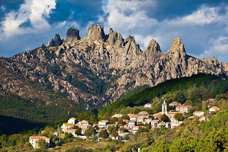 Vue sur le village de Zonza, niché au pied des aiguilles de Bavella, une étape incontournable pour découvrir le patrimoine culturel et historique de la Corse lors d’un séjour à Sainte-Lucie de Porto-Vecchio.