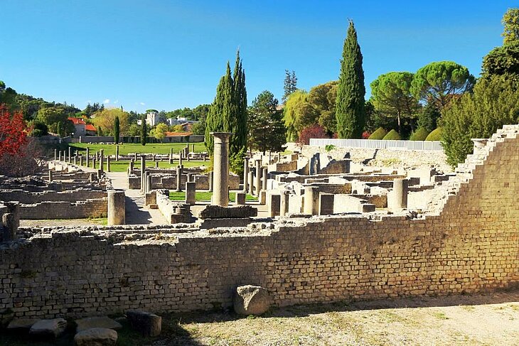 Sites antiques de Vaison-la-Romaine Vestiges gallo-romains et colonnes des sites antiques de Vaison-la-Romaine, entourés d’arbres sous un ciel bleu.