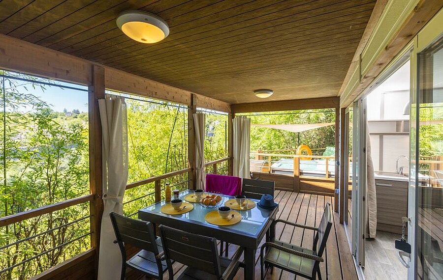 Terrasse en bois d’un mobil-home confortable en camping proche de Salavas, idéale pour un séjour nature en famille.