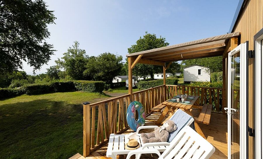 Terrasse en bois d’un mobil-home au camping Le Panoramic, location tout près de Moëlan-sur-Mer, idéale pour des vacances en plein air.