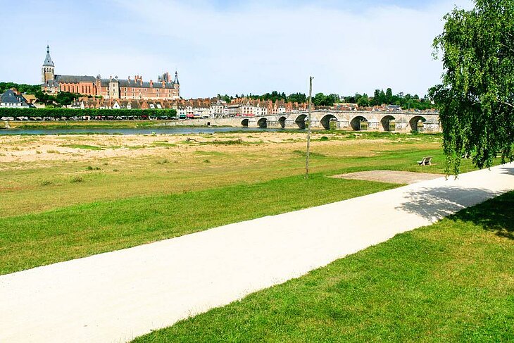 Chemin de promenade le long de la Loire à Poilly-lez-Gien, avec vue sur le château de Gien et le pont historique