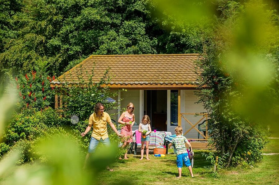Famille profitant d’une location de chalet en pleine nature dans un camping du Grand Est. Un séjour convivial et ressourçant au cœur d’un environnement verdoyant.