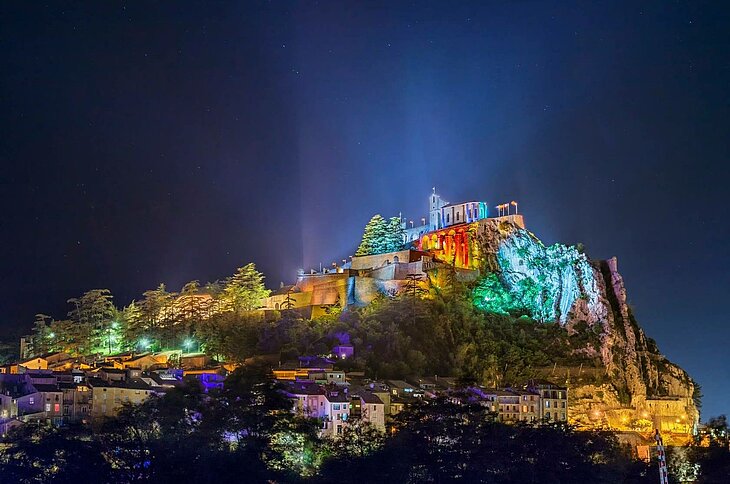 Illumination nocturne de la citadelle de Sisteron lors des Nuits de la Citadelle, un festival emblématique mêlant spectacles et concerts, parmi les activités incontournables à découvrir tout au long de l’année.