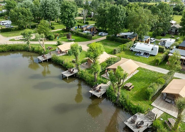Camping L'Étang à Brissac Vue aérienne du Camping L'Étang à Brissac-Loire-Aubance, avec des hébergements toilés et leurs terrasses au bord de l'étang.