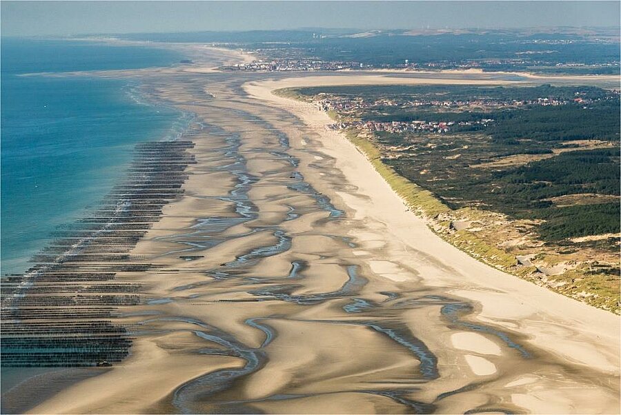 Vue aérienne de la plage de la Baie de Somme avec ses étendues de sable et ses marées, un paysage emblématique pour des vacances en camping dans les Hauts de France.