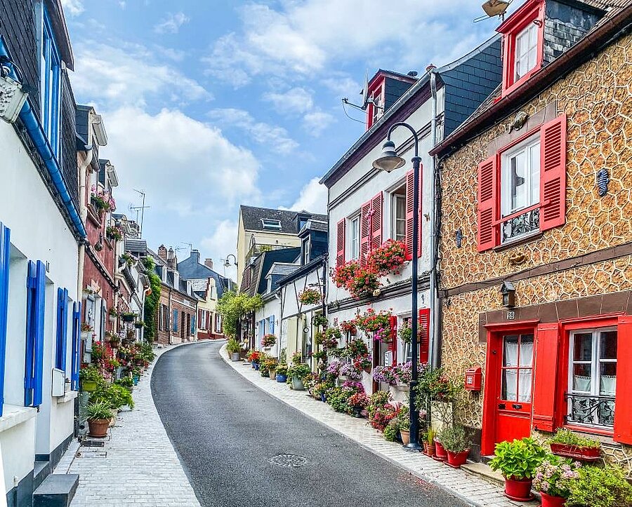 Ruelle pavée bordée de maisons colorées et fleuries à Saint-Valery-sur-Somme, cœur historique de la Baie de Somme.