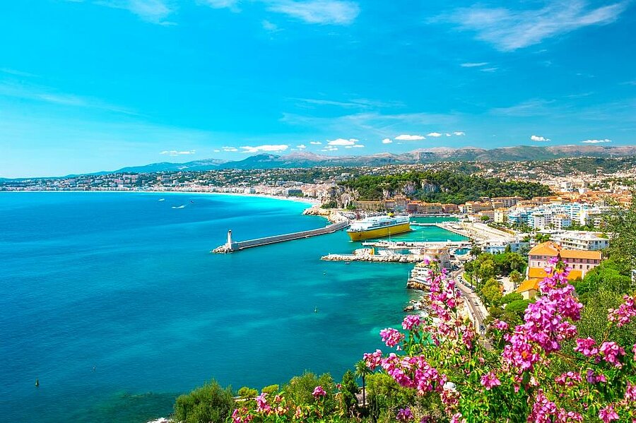 Vue sur le port de Nice, la Méditerranée et les collines environnantes avec fleurs méditerranéennes, à proximité d’un camping sur la Côte d’Azur.