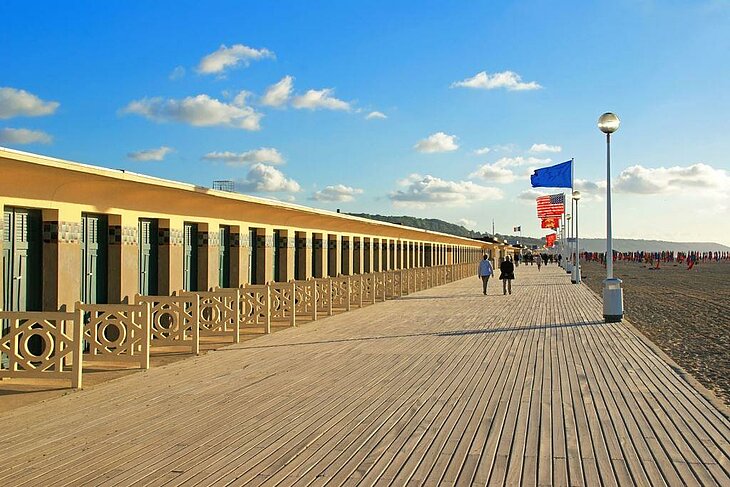 Plage de Deauville Promenade en bois et cabines de plage à Deauville en Normandie, drapeaux face à la mer, sortie conviviale entre amis entre plage et casino.