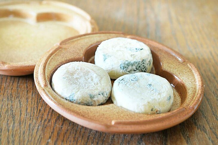 Trois Picodons affinés sur assiette en terre cuite, spécialité à savourer autour de Joannas lors d’une halte gourmande.