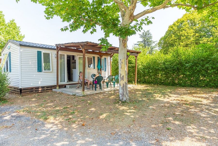 Mobil-home avec terrasse ombragée dans un camping des Alpes-de-Haute-Provence, offrant confort et tranquillité pour des vacances en famille.