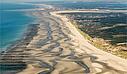Vue aérienne spectaculaire de la baie de Somme, avec ses étendues de vasières, marais et canaux naturels formant un paysage unique et préservé.