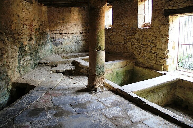 Anciennes tanneries à Saint-Antonin-Noble-Val Intérieur en pierre des anciennes tanneries de Saint-Antonin-Noble-Val, avec bassins de travail et pilier central.