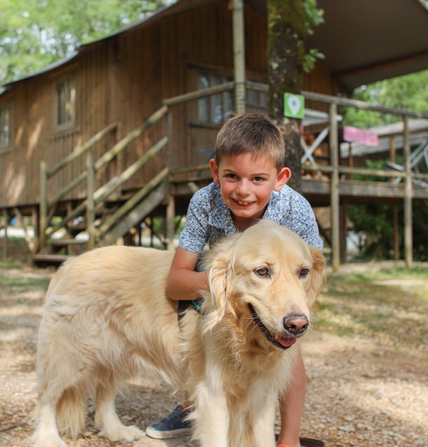 Un enfant avec son chien dans un camping